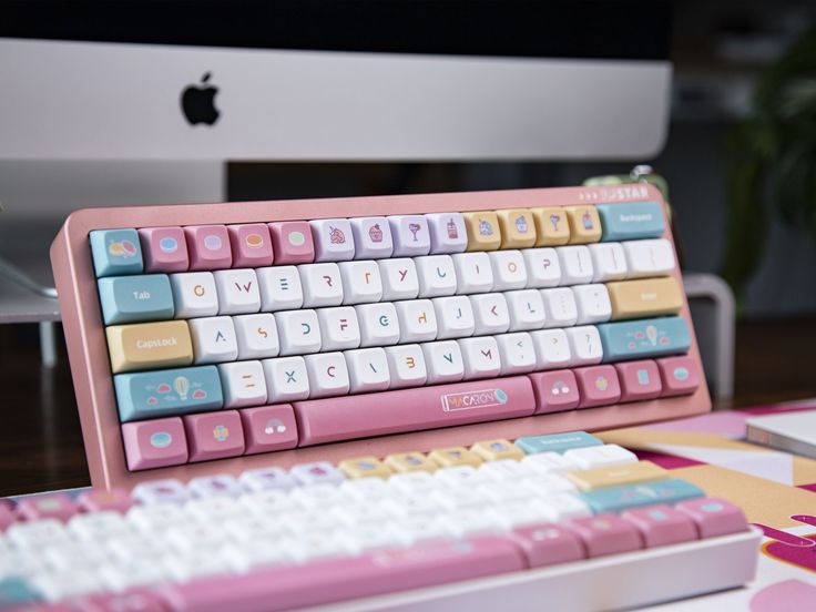 a pink and white keyboard sitting on top of a desk