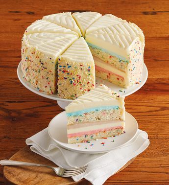 a cake with white frosting and multi colored sprinkles sits on a plate