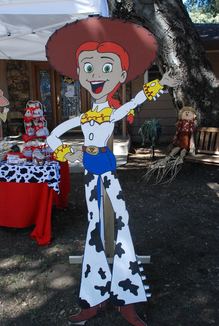 a paper cut out of a cartoon character is standing in front of a table with a cake on it