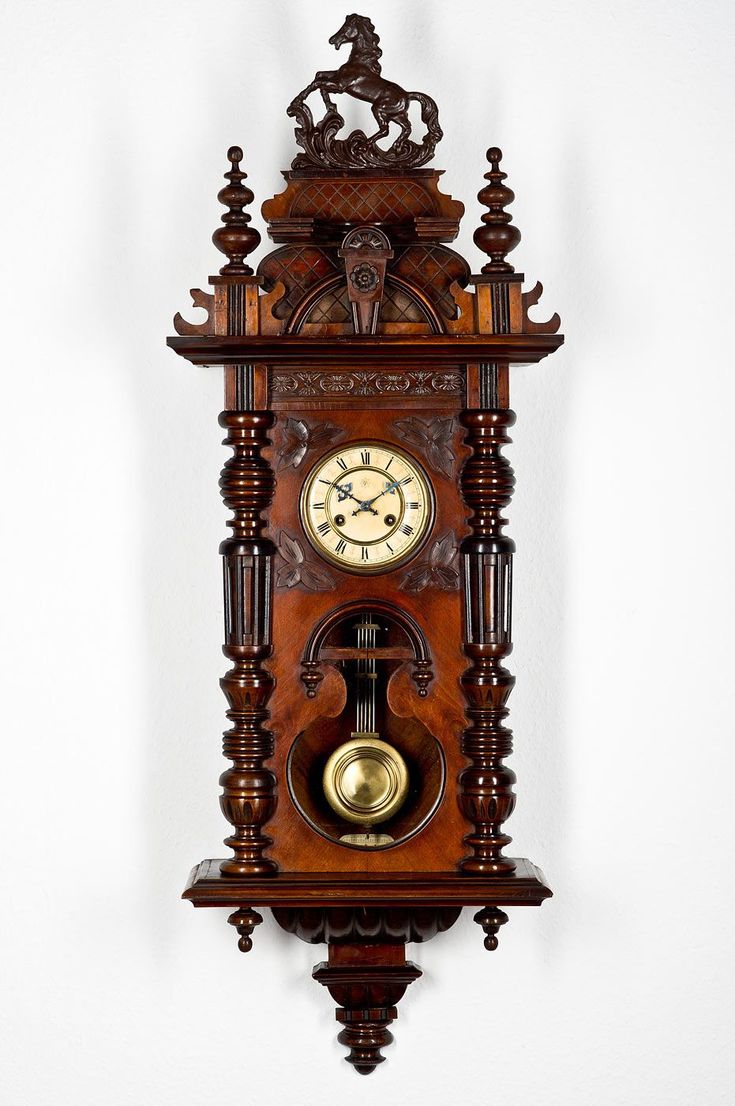 an ornate wooden wall clock hanging on the wall