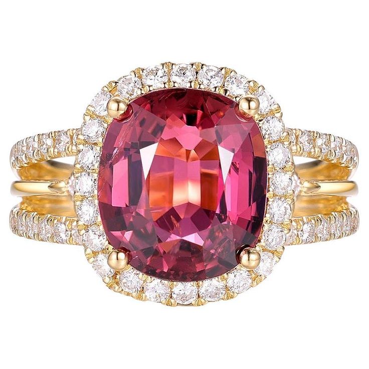 This exquisite ring is a stunning piece of jewelry crafted in luxurious 18-karat yellow gold. At its center is a captivating 4.01-carat cushion-cut tourmaline, displaying a rich and vibrant hue that draws the eye. The tourmaline is elegantly framed by a halo of sparkling diamonds, totaling 0.75 carats, which enhance its brilliance and add a touch of opulence. The band features a delicate pavé setting of diamonds, creating a continuous shimmer that complements the central gemstone beautifully. Th Luxury 14k Gold Ruby Wedding Ring, Elegant Yellow Gold Diamond Ring With Gemstone, Luxury Yellow Gold Ruby Ring With Center Stone, Luxury Ruby Rings With Prong Setting, Luxury Gold Cushion Cut Rings, Luxury Gia Certified Yellow Gold Cluster Ring, Luxury Ruby Jewelry With Halo Design, Luxury Gia Certified Cluster Ring In Yellow Gold, Yellow Gold Cushion Cut Topaz Ring