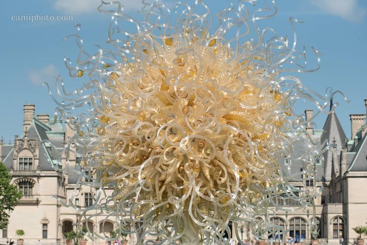 a large glass sculpture in front of a castle