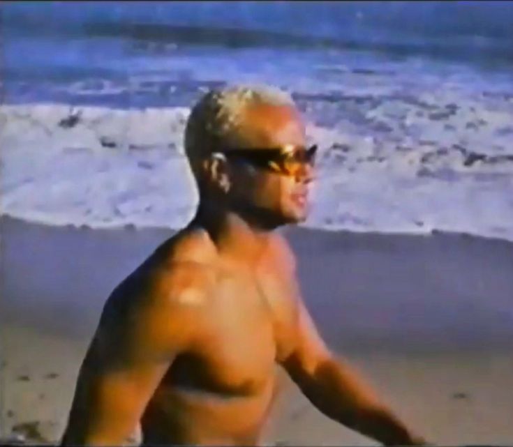 an older man wearing sunglasses on the beach