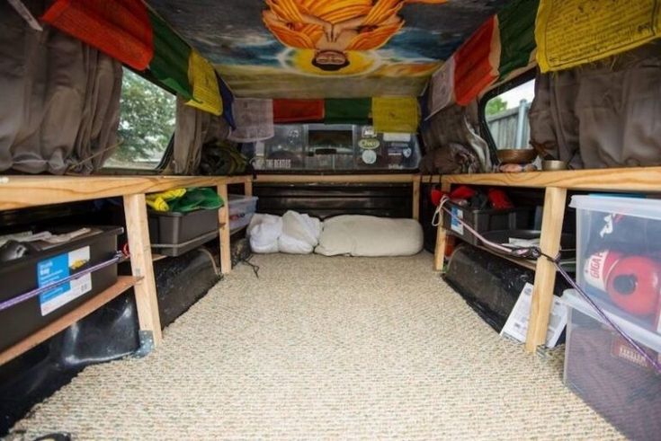 the inside of a van with several beds and other items on the floor in it