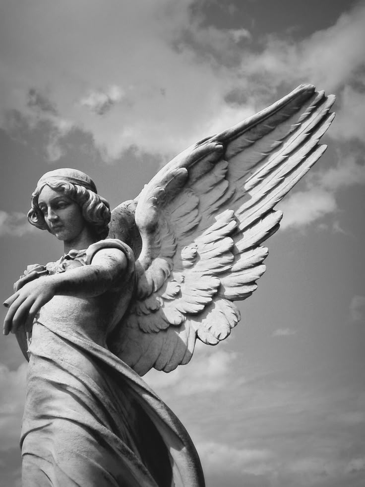 an angel statue is shown against a cloudy sky