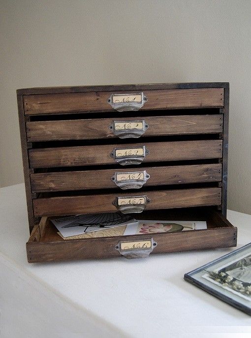 an old wooden drawer is open on a table next to a framed photograph and other items