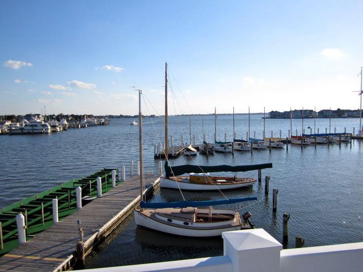 several boats are docked in the water at a dock