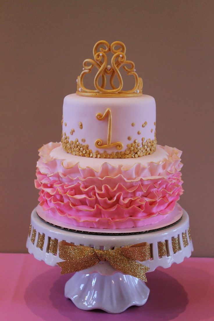 a three tiered cake decorated with pink and gold ruffles