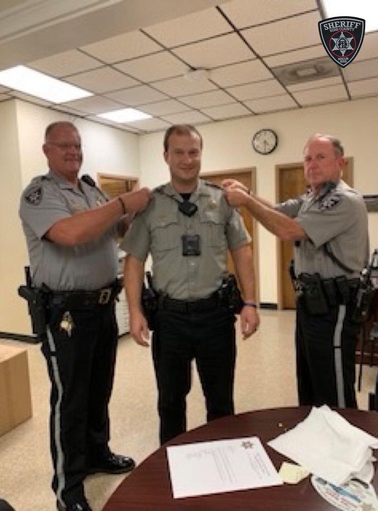 two police officers standing next to each other near a table with papers and pens on it