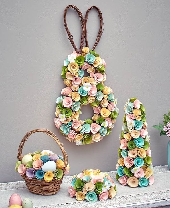 a number six made out of paper flowers next to an easter basket with eggs in it