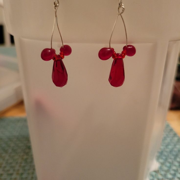 Homemade Red Beaded Earring With Silver Plated Fish Hook Backings Each Earring Has 4 Small Glass Beads, 2 Glass Drop Beads, And A Plastic Middle Bead. Red Sterling Silver Beaded Earrings, Elegant Red Teardrop Beaded Earrings, Red Beaded Drop Crystal Earrings, Red Czech Glass Beaded Earrings With Dangling Beads, Red Beaded Crystal Drop Earrings, Nickel-free Red Beaded Sterling Silver Earrings, Red Sterling Silver Nickel-free Beaded Earrings, Red Beaded Sterling Silver Earrings, Red Beaded Czech Glass Earrings