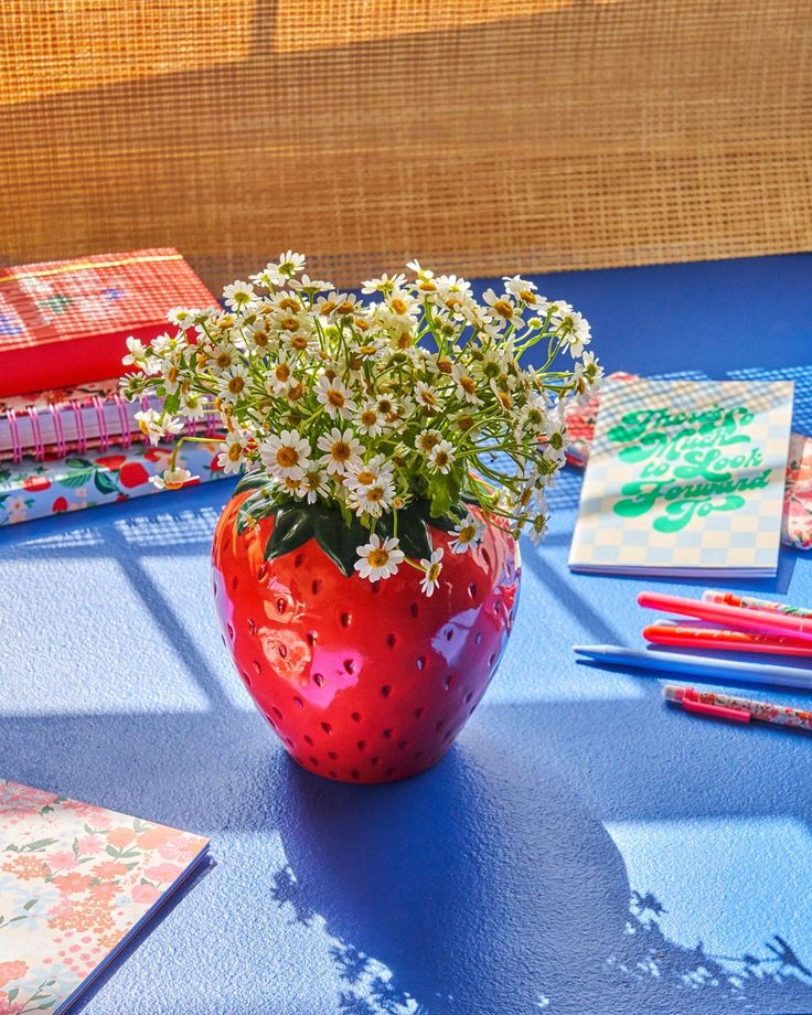 strawberry vase with white flowers on blue surface with desk accessorie scattered throughout New Yorker Loft, Giant Strawberry, Large Flower Vases, Kristina Webb, Koti Diy, Strawberry Decorations, Tanah Liat, Strawberry Fields, Keramik Vase