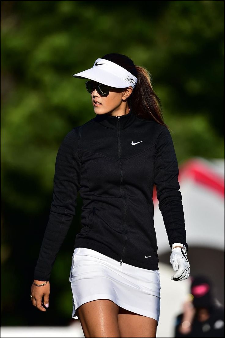 a female tennis player is walking on the court with her racquet in hand