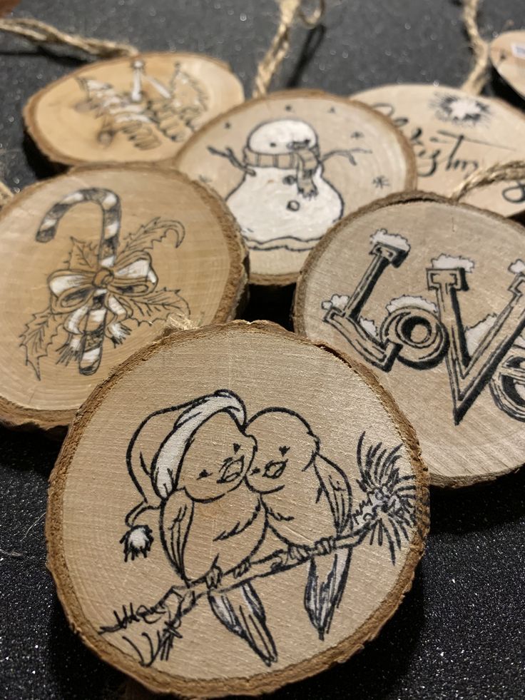 some wood slices are decorated with hand drawn love images and words on them, along with twine string