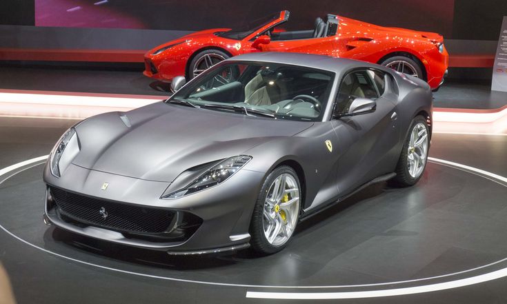 two sports cars on display at an auto show