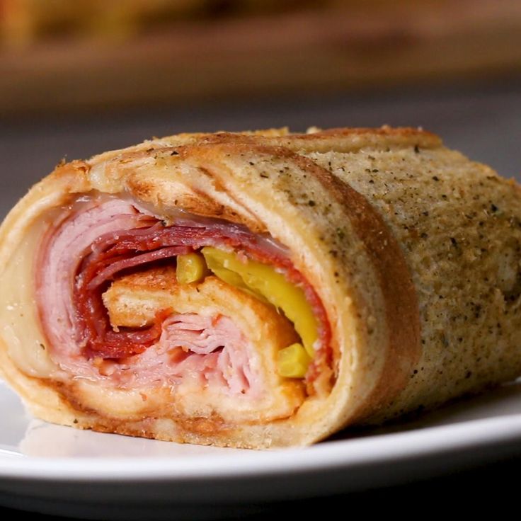 a close up of a sandwich on a plate with meat and cheese in the middle