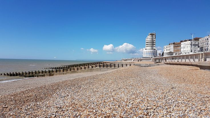 an empty beach with buildings in the background