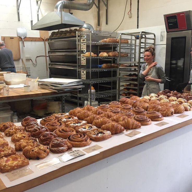 people standing in front of a counter full of baked goods