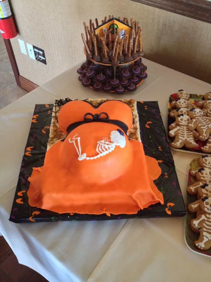 a table topped with cakes covered in frosting and skeleton decorations on top of it