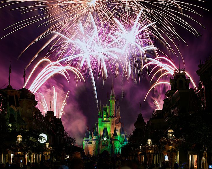 fireworks are lit up in the sky above a castle at disney's magic kingdom