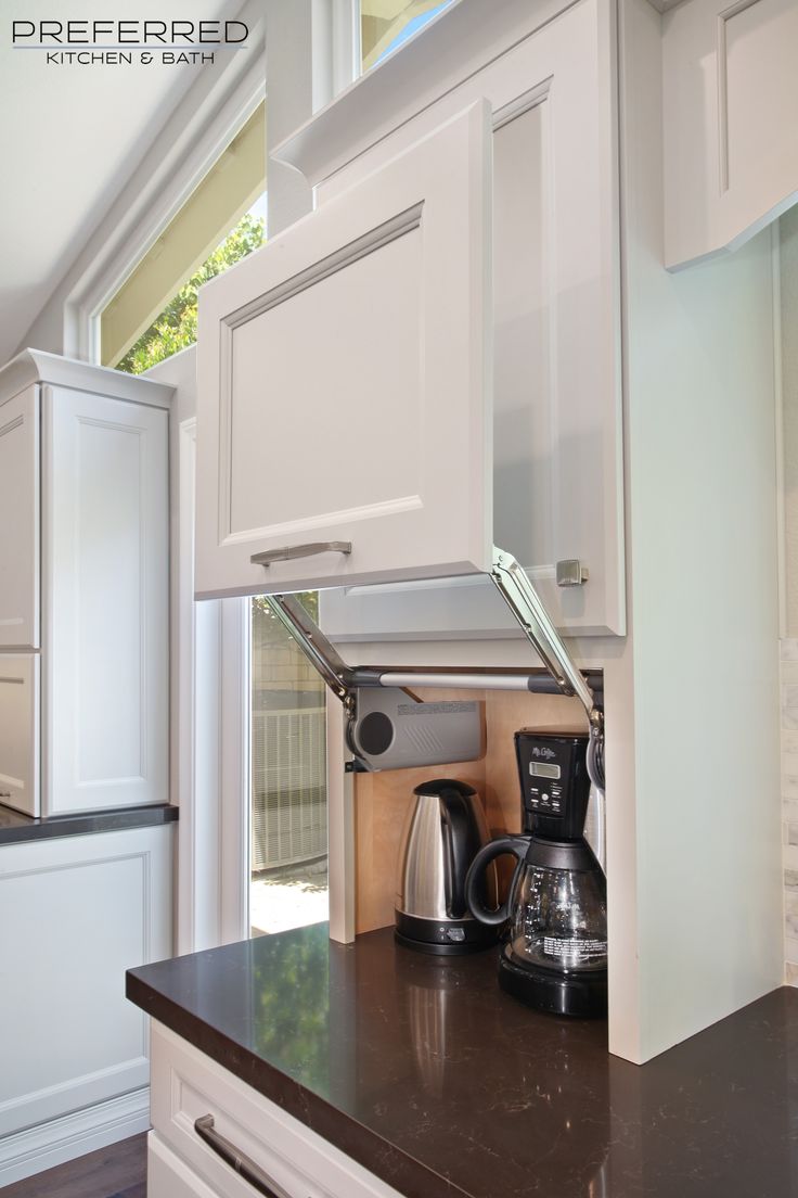 a kitchen with white cabinets and black counter tops