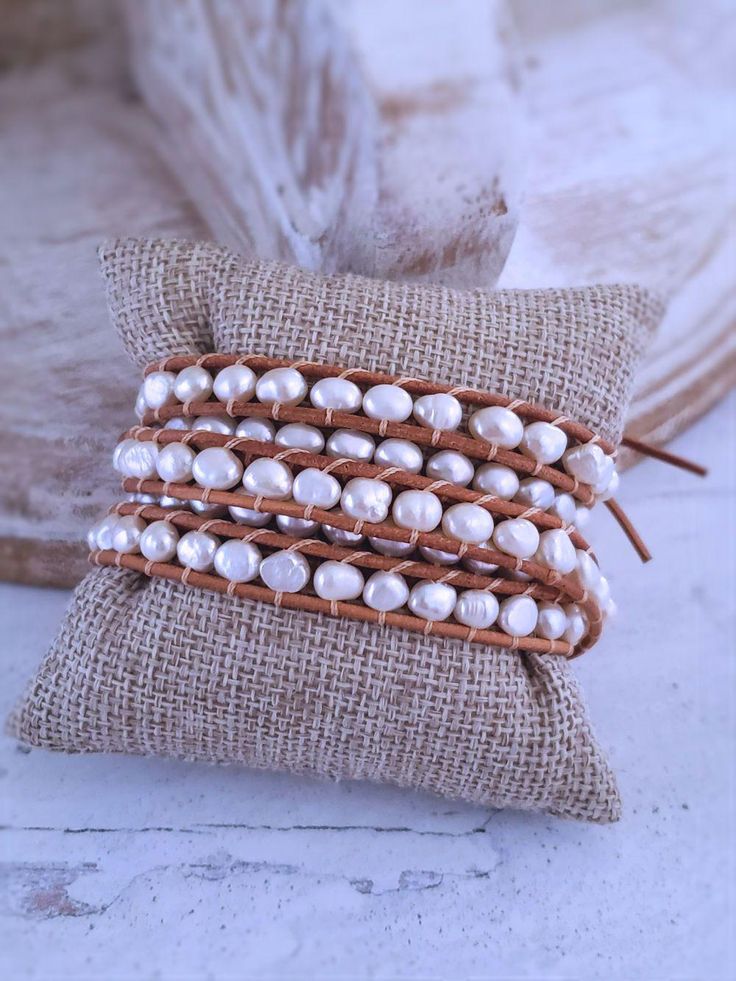 Beautiful genuine freshwater pearls are woven into these always on-trend leather pearl wrap bracelets. Wearing one of these bracelets will make you feel casually elegant since the pearls give a classy look to a traditionally bohemian style wrap bracelet. Choose from white pearls on natural tan leather or white pearls on dark brown leather. This pearl bracelet wraps around the wrist 5 times and is adjustable closure for flexible sizing. Bracelets are approximately 37 inches long and are adjustabl Elegant Adjustable Hand Wrapped Pearl Bracelet, Elegant Brown Wrap Bracelet As A Gift, Handmade Adjustable Luxury Pearl Bracelet, Elegant Beaded Leather Bracelet Gift, Elegant Brown Hand Wrapped Leather Bracelet, Handmade Elegant Leather Bracelet, Elegant Handmade Leather Bracelet, Elegant Hand Wrapped Leather Bracelet, Elegant Hand Wrapped Leather Bracelet Gift