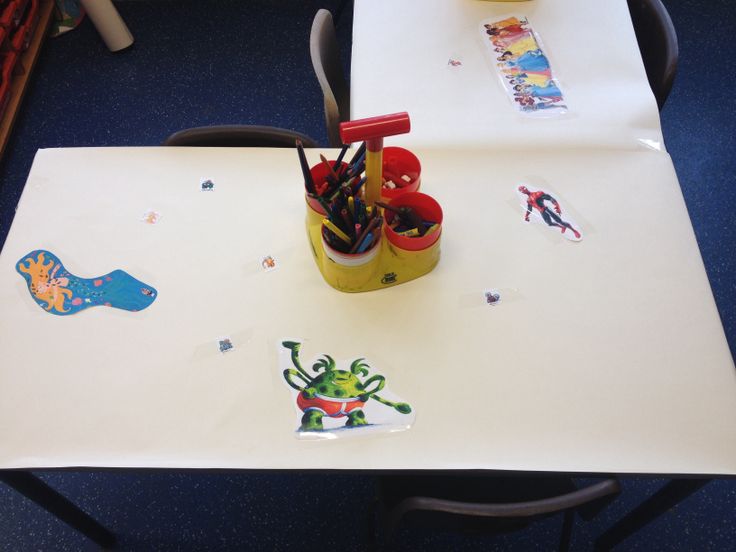 a table with some pens and pencils on it in the middle of a room