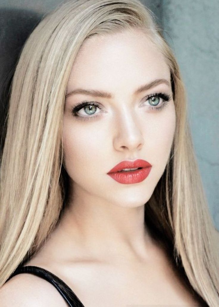 a woman with long blonde hair and red lipstick is posing for the camera, she has green eyeshadow on her face