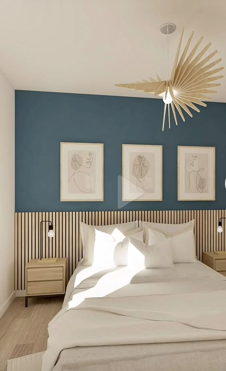 a bedroom with blue walls and white bedding, artwork on the wall above it