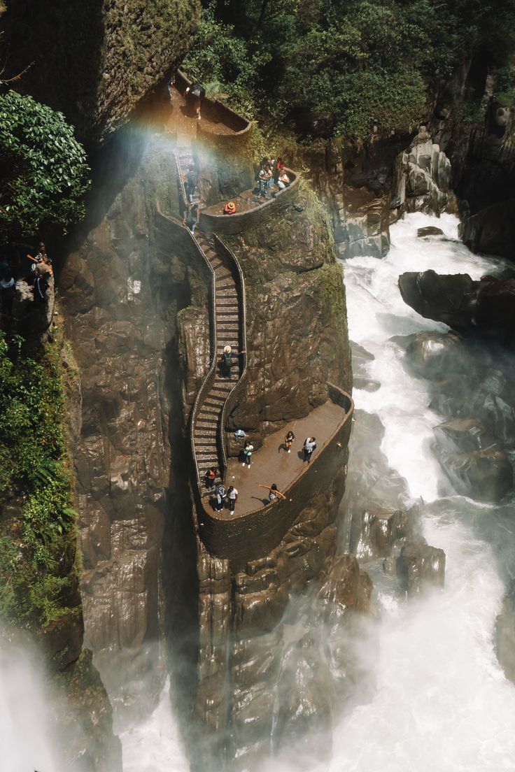 an aerial view of a waterfall with stairs leading up to the falls and people standing on it