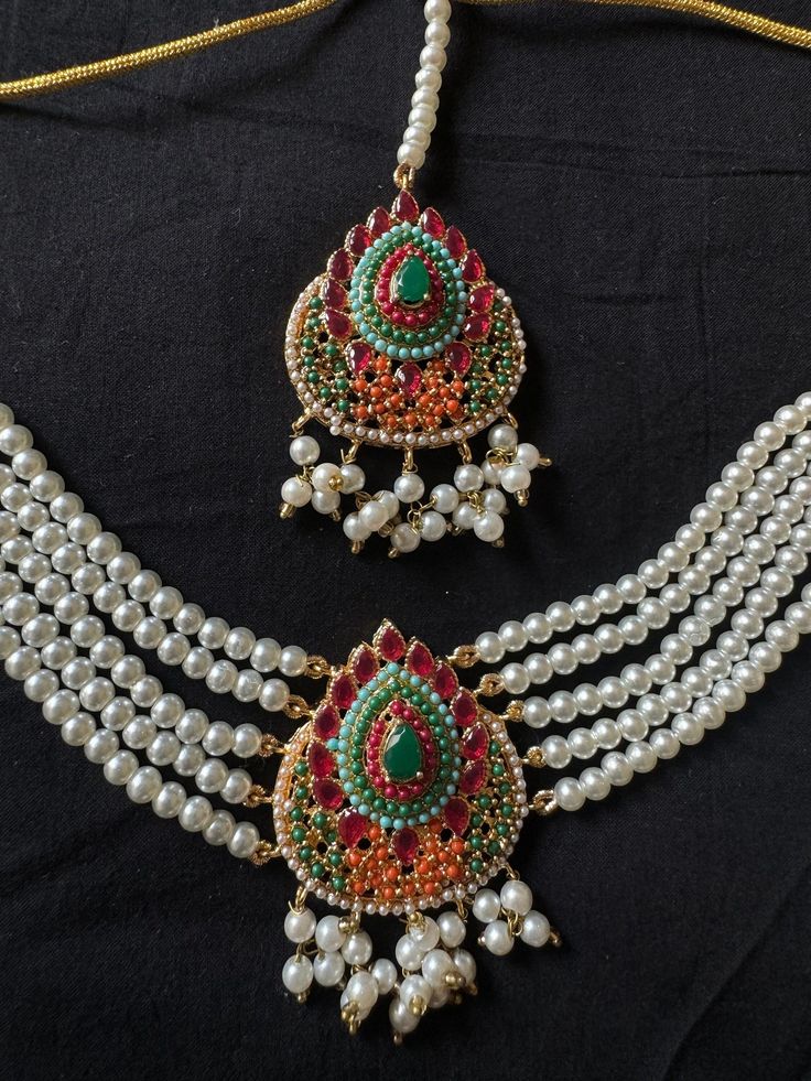 The jewelry set being offered here is a traditional Noratan bridal set, often worn during weddings or other formal occasions in Indian and Pakistani cultures. It is a multicolor set that can complement with many outfits and can be worn at many formal occasions. Here's a detailed description of this Navratan set  - **Noratan Bridal Choker The choker is  grand and intricate, typical of Noratan designs. It  features a combination different color embedded beads on a golden background.  The design is classic traditional, reflecting a regal and opulent style, perfect for a bridal ensemble. - **Matching Earrings The earrings in this set  complement the choker, dangling big statement jhumkas with a similar pattern of stones and intricate gold work. The large jhumka design add elegance and balance Traditional Jewelry Sets With Latkans For Diwali, Chandbali Bridal Sets For Diwali Puja, Chandbali Bridal Sets For Puja And Diwali, Festive Bridal Sets With Latkans For Diwali, Traditional Meenakari Jhumkas For Wedding, Heavy Bridal Sets For Diwali Puja, Heavy Bridal Sets For Puja During Diwali, Traditional Multicolor Chandbalis With Cutdana, Traditional Bridal Earrings With Stone Work For Wedding