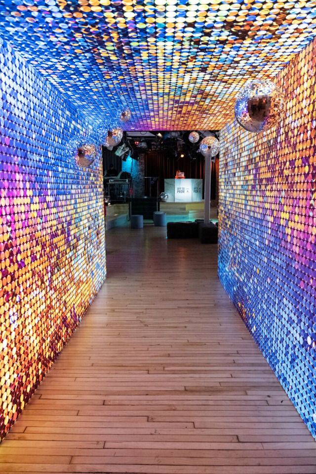 the inside of a building with wooden floors and colorful lights