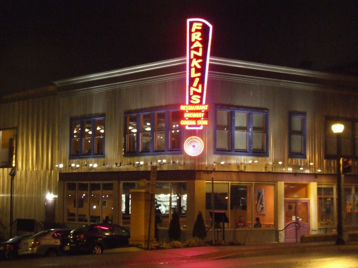 a building that has a sign on the front and side of it at night time