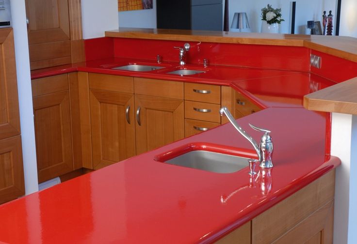 a kitchen with red counter tops and wooden cabinets