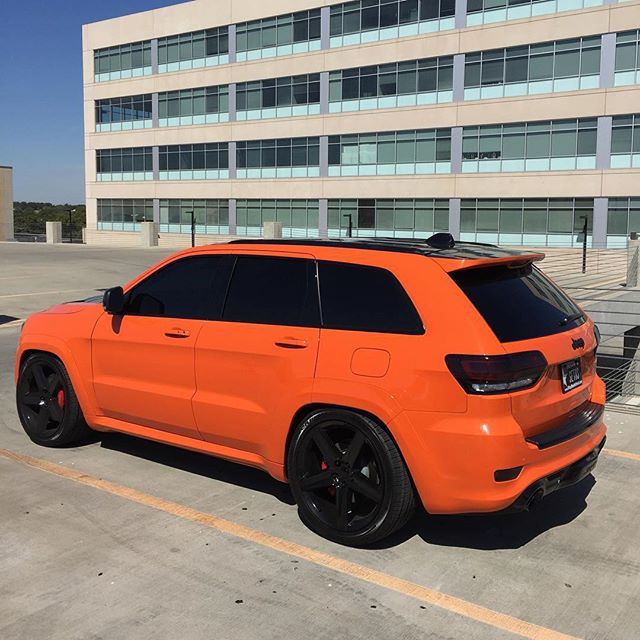 an orange jeep parked in front of a building