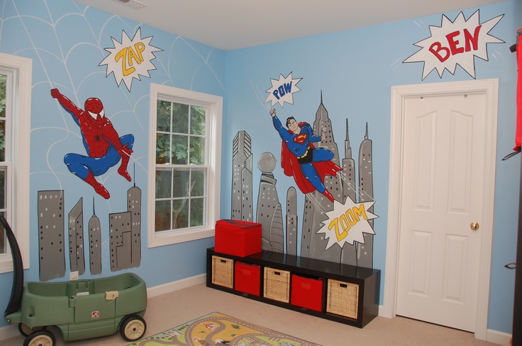 a child's room decorated in blue and red with superheros on the wall