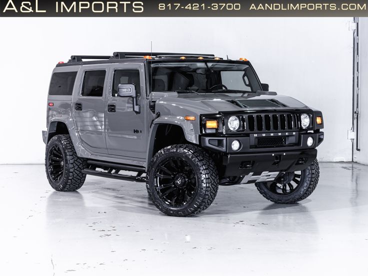 a grey hummer truck is parked in a white room with black wheels and tires