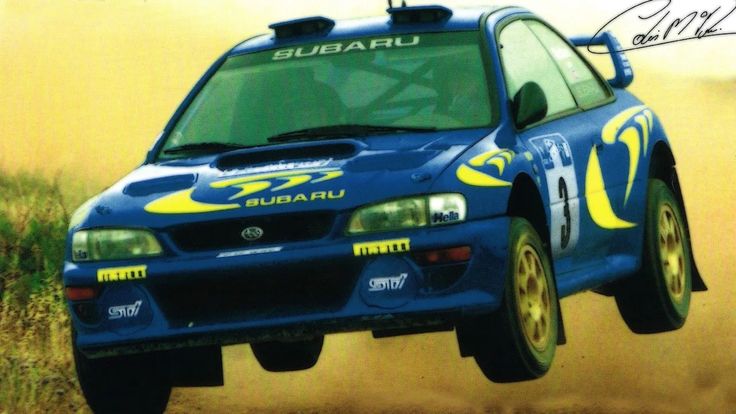 the subaru rally car is flying through the air in mid - air with dust behind it