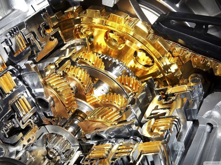 the inside of a mechanical device with gold gears