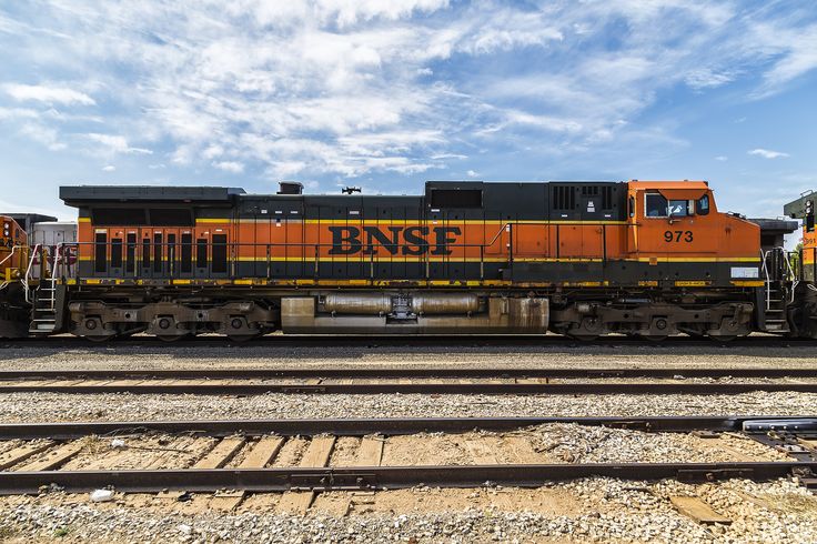 an orange and black train engine sitting on the tracks next to some other railroad tracks