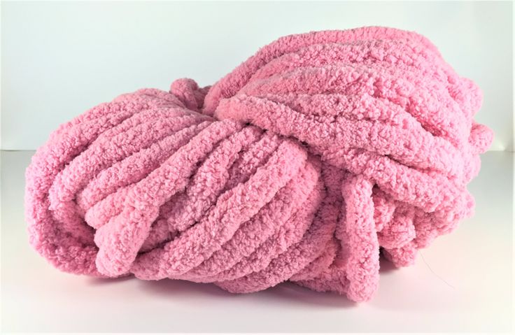 a pile of pink towels sitting on top of a white table