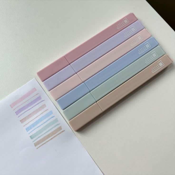 a stack of pastel colored papers sitting on top of a white table