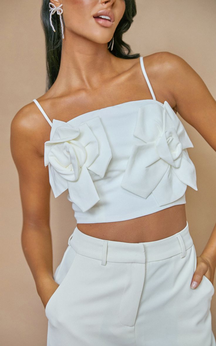 Get ready for a party night in style with our Stephany Top. This floral applique strappy lace-up back cami top is the perfect addition to your wardrobe. Made from high-quality polyester, it features a flattering straight fit and sleeveless design that is both comfortable and chic. The white color adds a fresh touch to any outfit, while the crop length adds a trendy twist. Whether you're going out with friends or hitting the dance floor, this top will make sure all eyes are on you. Get ready to t Spring Evening Tank Top With Adjustable Straps, Sleeveless Party Top With Delicate Straps, Sleeveless Top With Delicate Straps For Party, Spring Cami Crop Top For Night Out, Spring Crop Top For Party With Tank Straps, Chic Tank Straps Crop Top For Party, Spring Party Tank Top With Straps, Chic Party Tank Top With Straps, Chic Tops With Tank Straps For Date Night