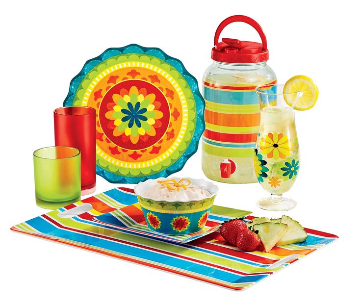 a colorful table setting with fruit and drinks