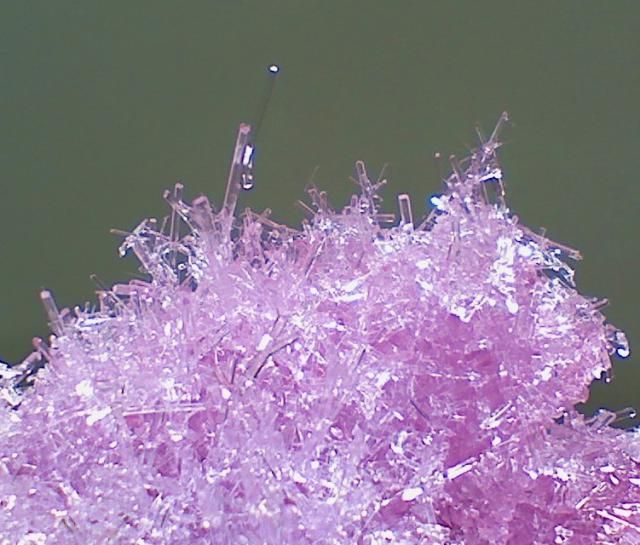 a close up view of some purple glass with needles sticking out of it's center