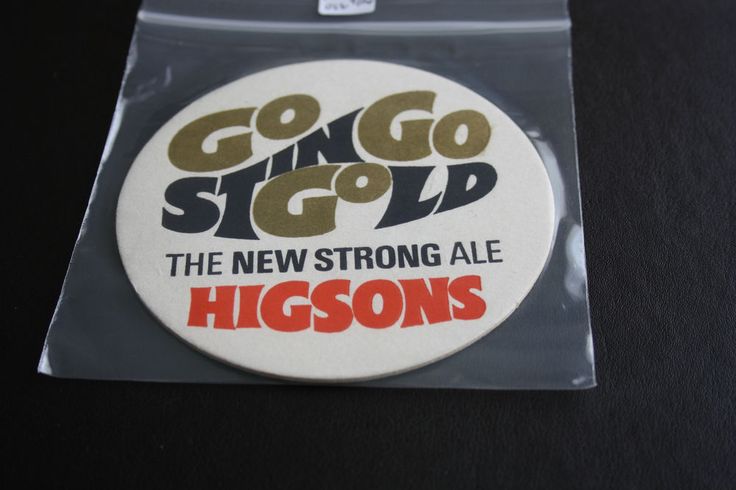 a button with the words, go sing gold and the new strong ale logo on it