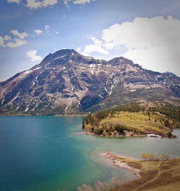 the mountains are covered in snow and green water