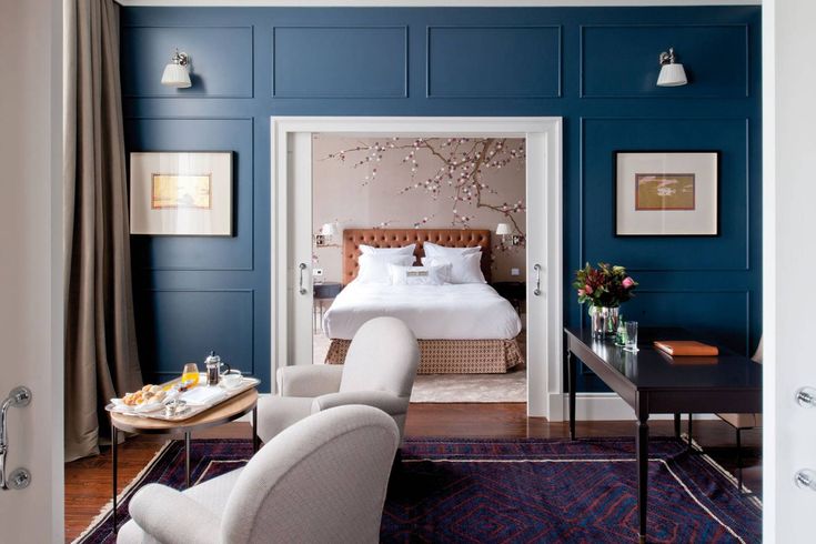 a bedroom with blue walls and white furniture