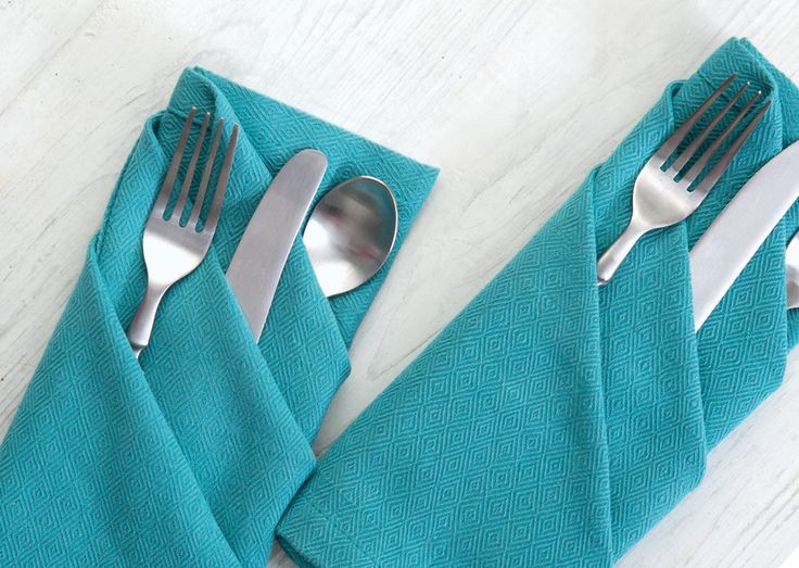 two forks and spoons sitting on top of blue napkins