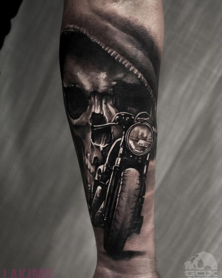 a man's arm with a skull riding a motorcycle